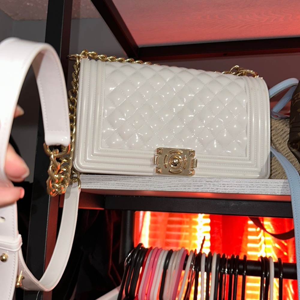 Shiny white purse with gold accents.